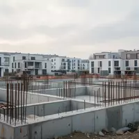 Eine Baustelle für neue Wohngebäude in Deutschland mit Betonfundamenten und Stahlarmierungen bei bewölktem Himmel. - Foto: über boerse-global.de