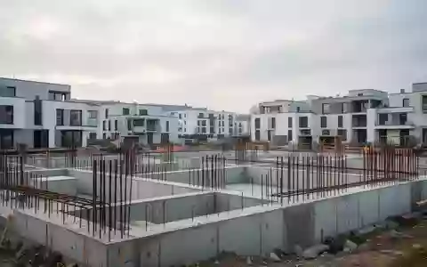Eine Baustelle für neue Wohngebäude in Deutschland mit Betonfundamenten und Stahlarmierungen bei bewölktem Himmel. - Foto: über boerse-global.de