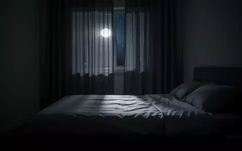 Ein ruhiges, abgedunkeltes Schlafzimmer bei Nacht mit sanftem Mondlicht, das auf ein unbenutztes Bett fällt. - Foto: über boerse-global.de