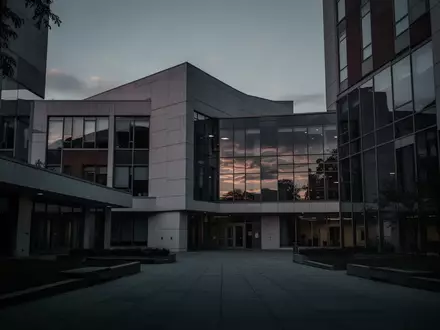 Ein modernes Universitätsgebäude in der Abenddämmerung, das leer und verlassen wirkt. - Foto: über boerse-global.de