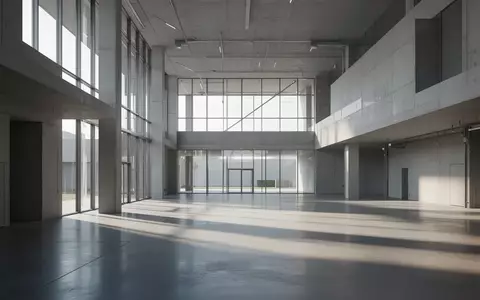 Ein minimalistisches, modernes Industriegebäude mit klaren geometrischen Linien und natürlichem Lichteinfall auf einem polierten Betonboden. - Foto: über boerse-global.de