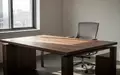 Ein heller, minimalistischer Arbeitsplatz mit einem leeren Schreibtisch und einem ergonomischen Bürostuhl in einem sonnendurchfluteten Raum. - Foto: über boerse-global.de