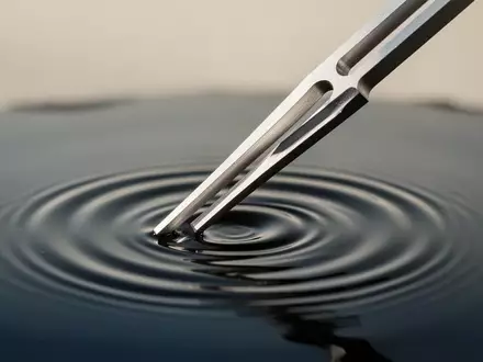 Eine Stimmgabel erzeugt konzentrische Wellen auf einer ruhigen Wasseroberfläche. - Foto: über boerse-global.de
