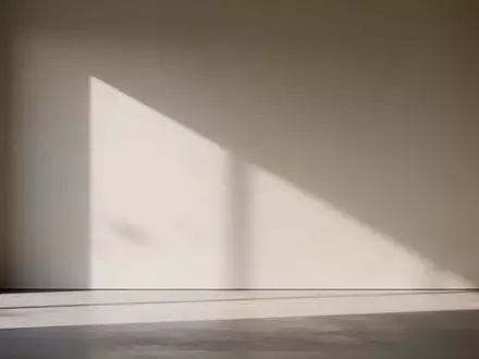 Ein minimalistisch gestalteter, sonnendurchfluteter Raum mit sanften Schatten an einer schlichten Wand. - Foto: über boerse-global.de