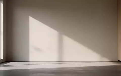 Ein minimalistisch gestalteter, sonnendurchfluteter Raum mit sanften Schatten an einer schlichten Wand. - Foto: über boerse-global.de
