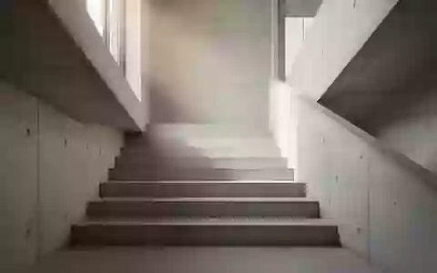 Eine minimalistische Betontreppe in einem hellen Gebäude, die nach oben führt, bei natürlichem Lichteinfall. - Foto: über boerse-global.de