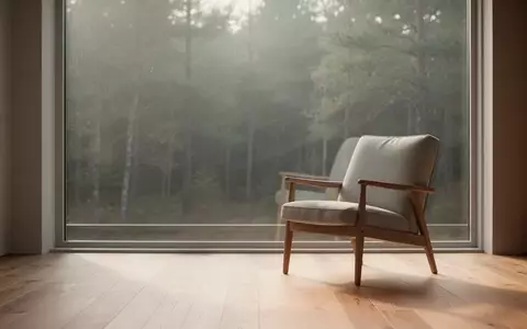 Ein heller, minimalistischer Raum mit einem leeren Stuhl vor einem Fenster, das auf einen ruhigen Wald blickt. - Foto: über boerse-global.de