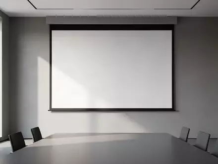 Ein minimalistischer, leerer Konferenzraum mit einer unbeschriebenen Projektionsfläche vor einer grauen Wand. - Foto: über boerse-global.de