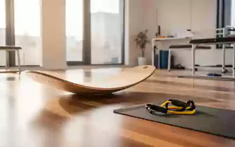 Ein heller, minimalistisch eingerichteter Physiotherapieraum mit Trainingsgeräten auf einem Holzboden bei natürlichem Lichteinfall. - Foto: über boerse-global.de