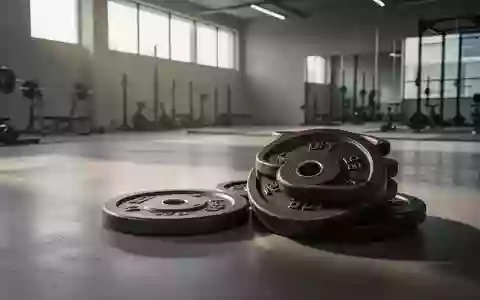 Leeres, minimalistisch gestaltetes Fitnessstudio mit Hantelscheiben auf einem Betonboden bei natürlichem Lichteinfall. - Foto: über boerse-global.de