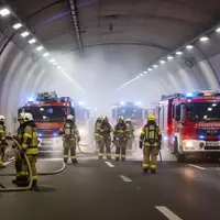 Einsatzkräfte bei einer großangelegten Übung in einem beleuchteten Straßentunnel. - Foto: über boerse-global.de