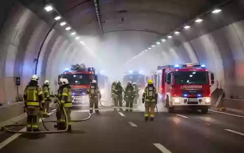 Einsatzkräfte bei einer großangelegten Übung in einem beleuchteten Straßentunnel. - Foto: über boerse-global.de