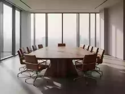 Ein leerer, modern eingerichteter Konferenzraum mit einem großen Holztisch und Stühlen vor einer Fensterfront. - Foto: über boerse-global.de