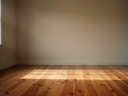 Ein minimalistischer, lichtdurchfluteter Raum mit Holzboden und einer leeren Wand, der Ruhe und Achtsamkeit ausstrahlt. - Foto: ĂŒber boerse-global.de