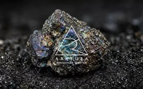 Irisierende Seltenerdmineralien auf einem dunklen industriellen Untergrund mit dramatischer Beleuchtung. - Foto: über boerse-global.de