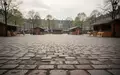 Ein leerer, gepflasterter Marktplatz im Frühling mit verschwommenen, unbesetzten Marktständen im Hintergrund. - Foto: über boerse-global.de