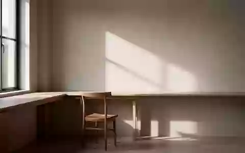 Ein minimalistischer, lichtdurchfluteter Raum mit einem leeren Schreibtisch und weichem Schattenwurf. - Foto: über boerse-global.de