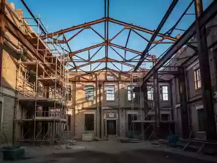 Rohbau eines ehemaligen Gewerbegebäudes bei der Umwandlung in Wohnraum mit Gerüsten und sichtbarer Stahlkonstruktion. - Foto: über boerse-global.de