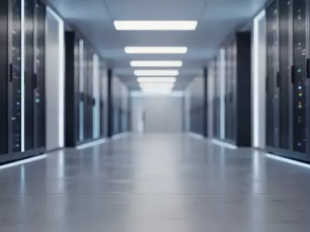 Modernes, minimalistisches Design eines Rechenzentrums mit blauer Beleuchtung und verschwommenen Server-Racks im Hintergrund. - Foto: ĂŒber boerse-global.de