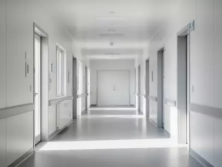 Ein heller, moderner Klinikflur in minimalistischem Design ohne Personen oder Geräte, der eine ruhige medizinische Umgebung symbolisiert. - Foto: über boerse-global.de