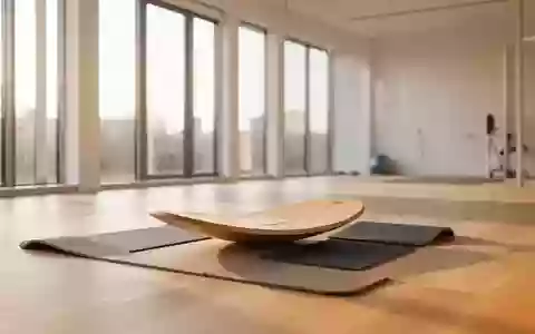 Heller, minimalistischer Therapieraum mit einem Balancebrett und Sportmatten auf einem hellen Holzboden. - Foto: über boerse-global.de
