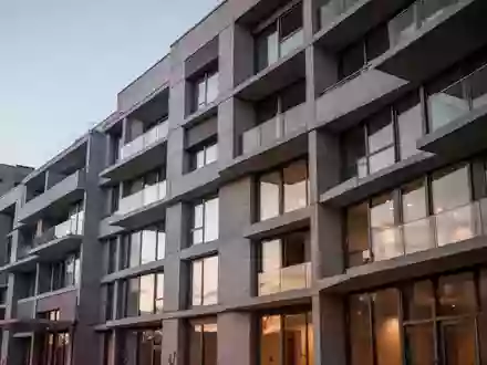 Fassade eines modernen Wohngebäudes in der Dämmerung mit klaren architektonischen Linien und neutralen Texturen. - Foto: über boerse-global.de