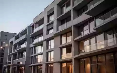 Fassade eines modernen Wohngebäudes in der Dämmerung mit klaren architektonischen Linien und neutralen Texturen. - Foto: über boerse-global.de