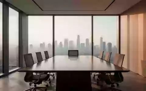 Ein minimalistischer, moderner Konferenzraum mit einem polierten Holztisch und natürlichem Tageslicht. - Foto: über boerse-global.de