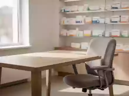 Ein minimalistischer Beratungsraum in einer Apotheke mit einem Holztisch und einem Stuhl bei natürlichem Lichteinfall. - Foto: über boerse-global.de