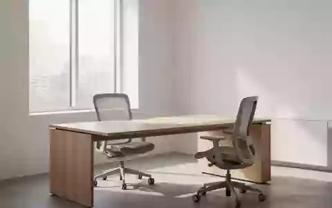 Ein heller, minimalistischer Arbeitsplatz mit einem leeren Schreibtisch und ergonomischem Stuhl in einer ruhigen Umgebung. - Foto: über boerse-global.de
