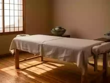 Ein minimalistischer Behandlungsraum für traditionelle Massagetechniken mit einer schlichten Massageliege und Naturmaterialien. - Foto: über boerse-global.de