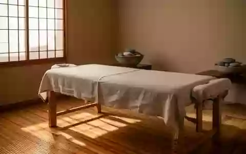 Ein minimalistischer Behandlungsraum für traditionelle Massagetechniken mit einer schlichten Massageliege und Naturmaterialien. - Foto: über boerse-global.de