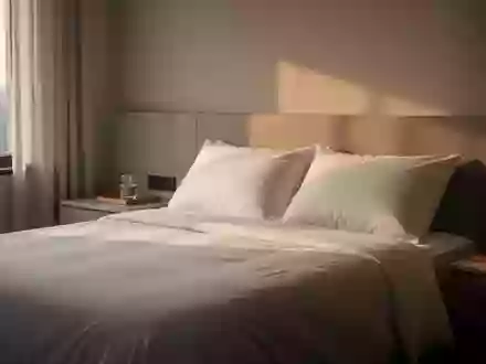 Ein minimalistisch eingerichtetes Schlafzimmer bei Tageslicht mit einem unbenutzten Bett und einem Nachttisch. - Foto: über boerse-global.de