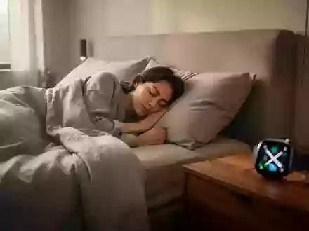 Eine Person schläft friedlich in einem modernen Schlafzimmer mit einer Smartwatch auf dem Nachttisch. - Foto: über boerse-global.de