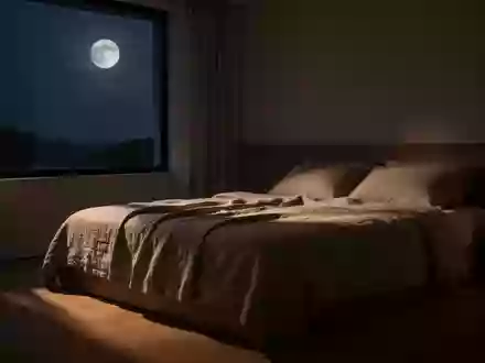 Ein minimalistisch eingerichtetes Schlafzimmer bei Nacht mit gedimmtem Mondlicht und neutraler Bettwäsche. - Foto: über boerse-global.de