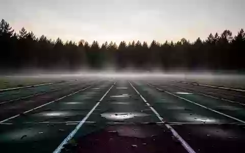 Eine leere, morgendliche Sportlaufbahn im Nebel als Symbol für die Risiken von Übertraining. - Foto: über boerse-global.de