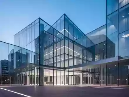 Moderne architektonische Struktur aus Glas und Stahl bei Dämmerung, die Stabilität und institutionelle Aufsicht symbolisiert. - Foto: über boerse-global.de