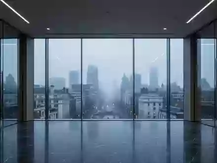 Ein minimalistisches, modernes Bürogebäude mit Glasfassade und Blick auf die Stadt bei Dämmerung. - Foto: über boerse-global.de