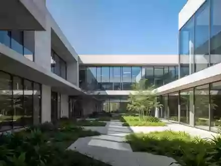 Moderner Innenhof eines Forschungscampus mit klaren architektonischen Linien und grüner Bepflanzung. - Foto: über boerse-global.de