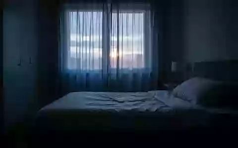 Ein unbewohntes Schlafzimmer im sanften Licht der Morgendämmerung, das Ruhe und Schlafqualität symbolisiert. - Foto: über boerse-global.de