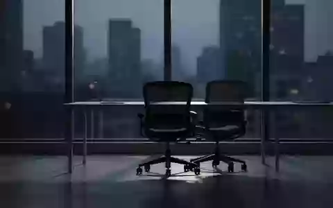 Ein leerer, ruhiger Büroraum in der Abenddämmerung mit Blick auf die dunkle Skyline, der das Gefühl von Überlastung vermittelt. - Foto: über boerse-global.de