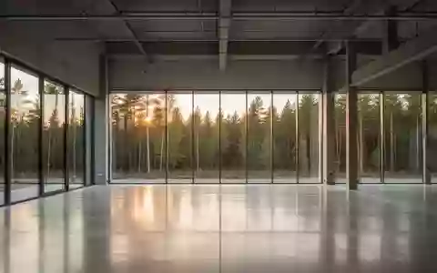 Modernes, nachhaltiges Industriegebäude mit großflächiger Verglasung und Blick in eine grüne Waldlandschaft. - Foto: über boerse-global.de