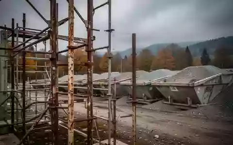 Leere Baustelle an einem Kieswerk mit Gerüstteilen unter einem bewölkten Himmel. - Foto: über boerse-global.de