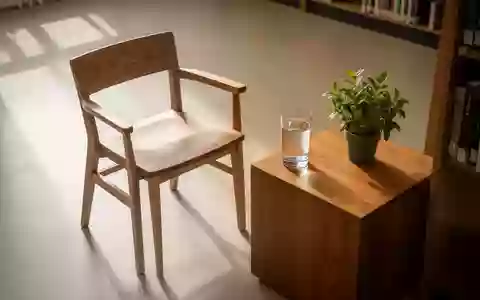 Ein sonnendurchfluteter, minimalistischer Lesebereich mit einem Holzstuhl und einer Pflanze, der Ruhe und geistige Klarheit symbolisiert. - Foto: über boerse-global.de