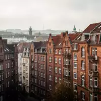 Dichte städtische Wohnbebauung mit historischen Ziegelbauten bei bewölktem Himmel. - Foto: über boerse-global.de