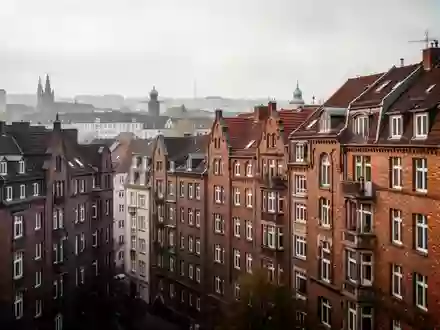 Dichte städtische Wohnbebauung mit historischen Ziegelbauten bei bewölktem Himmel. - Foto: über boerse-global.de
