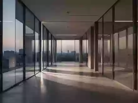 Ein moderner, minimalistischer Büroflur mit Glaswänden und polierten Betonböden bei Dämmerung. - Foto: über boerse-global.de
