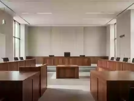 Ein minimalistischer, leerer Gerichtssaal mit polierten Holzoberflächen und natürlichem Lichteinfall. - Foto: über boerse-global.de