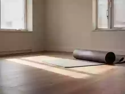 Ein sonnendurchfluteter, minimalistischer Raum mit einem aufgerollten Yogamatte auf einem Holzboden. - Foto: über boerse-global.de