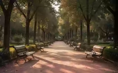 Leere Parkbänke auf einem von Bäumen gesäumten Weg in einem sonnigen Garten bei Barcelona. - Foto: über boerse-global.de